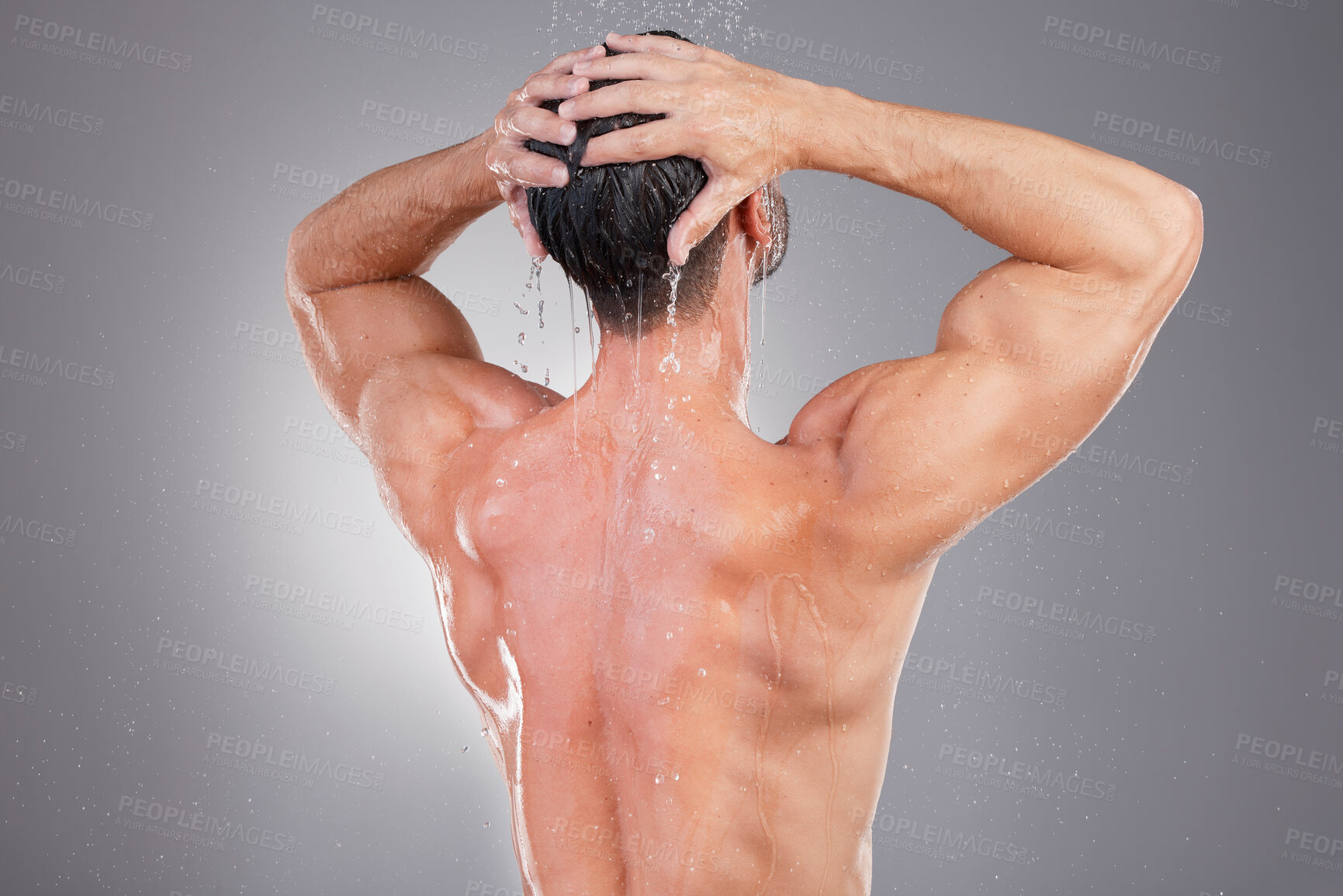 Buy stock photo Shower, cleaning and back of man with water in studio background for wellness, grooming and beauty. Skincare, bathroom hygiene and male smile for washing hair, clean body and soap for healthy skin