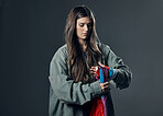 Protest, LGBTQ and woman with flag in studio wrapping it on hand for human rights and equality. Empowerment, sexuality and female political activist with bisexual material isolated by gray background