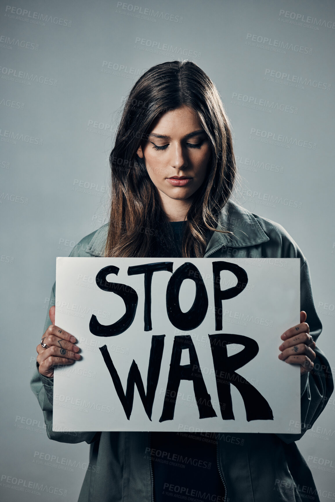 Buy stock photo War, stop and sad woman with a sign as a voice isolated on a grey studio background. Protest, crime and girl with a board against conflict, violence and danger with an opinion in Russia on a backdrop