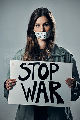 Buy stock photo War, stop and portrait of a woman with a sign while silent isolated on a grey studio background. Protest, crime and silenced girl with a board against conflict and violence in Russia on a backdrop