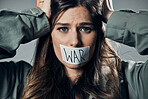 Woman, face and protest with tape on mouth in fear for cold war, armageddon or doomsday against gray studio background. Female activist with voice message to stop or end global violence in society