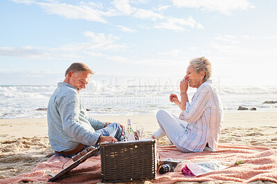 Buy stock photo Senior couple, romantic beach picnic and smile together in summer for conversation, memory and comic time. Elderly man, old woman and basket for food, wine and outdoor for sunshine, waves and love