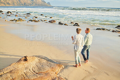 Buy stock photo Beach, love and a senior couple walking on the sand by the ocean or sea for romance or dating at sunset. Nature, summer or back with a mature woman and man taking romantic walk together on the coast