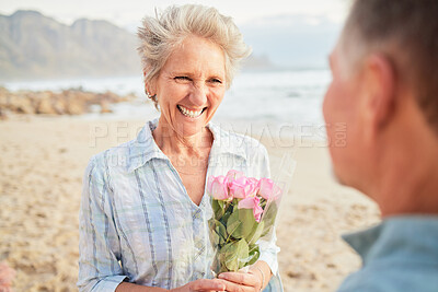 Buy stock photo Beach, flowers and valentines day with a senior couple in celebration of love together outdoor in nature. Romance, rose or smile with a happy mature woman and man celebrating on the coast in summer