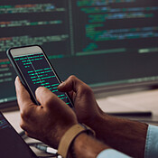 Phone in hands, code and man coding, programmer and software update ...