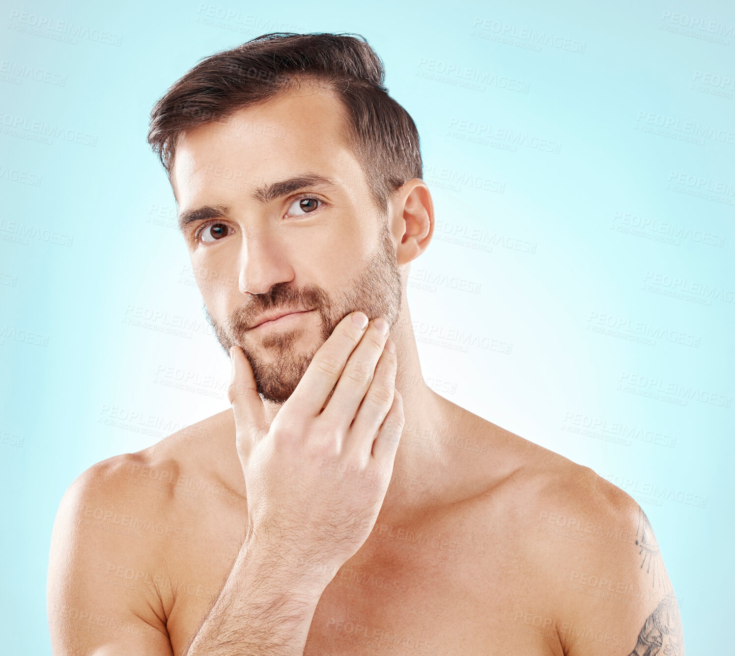 Buy stock photo Portrait, beauty and a man model grooming in studio on a blue background for natural skincare. Face, skin and beard with a handsome young male posing to promote health, treatment or wellness