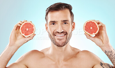 Buy stock photo Man, skincare and studio portrait with grapefruit for health, nutrition and cosmetic wellness by blue background. Young model, fruit and vitamin c for natural detox, facial skin glow and aesthetic