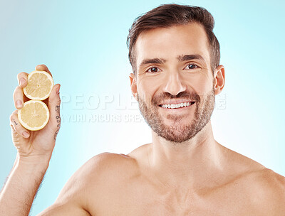 Buy stock photo Man, skincare and studio portrait with lemon for health, nutrition and cosmetic wellness by blue background. Happy young model, fruit and vitamin c for natural detox, facial skin glow and beauty