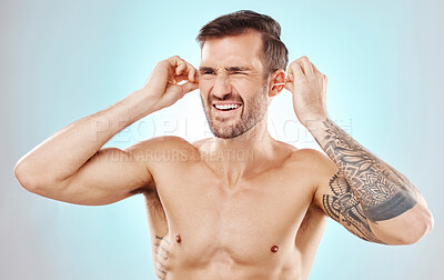 Buy stock photo Ear cleaning, cotton bud and wellness of a man with blue background in a studio. Healthcare, grooming and self care of a man doing morning routine for health, hygiene and wellbeing treatment