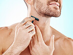 Hands, shaving and beard with a man grooming in studio on a blue background for skincare or hygiene. Shave, tattoo and neck with a male in the bathroom for hair removal as part of a morning routine