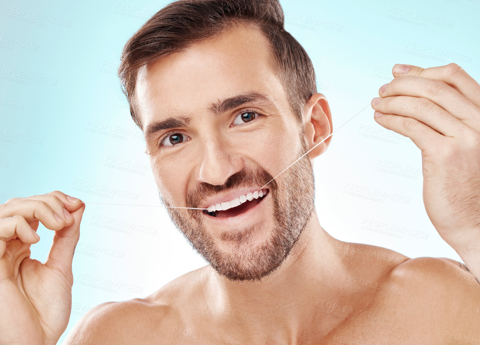 Buy stock photo Face, portrait and man with dental floss in studio isolated on a blue background. Oral health, hygiene or happy male model flossing teeth for wellness, cleaning or fresh breath, cosmetics or gum care