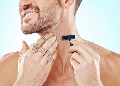 Buy stock photo Hands, shave and beard with a man grooming in studio on a blue background for skincare or hygiene. Shaving, tattoo and neck with a male in the bathroom for hair removal as part of a morning routine