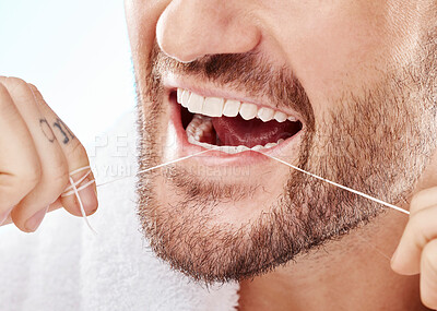 Dental, hygiene and man flossing his teeth in a studio for oral care, grooming or health. Wellness, healthy and closeup of male model doing fresh, clean and natural mouth routine by white background.