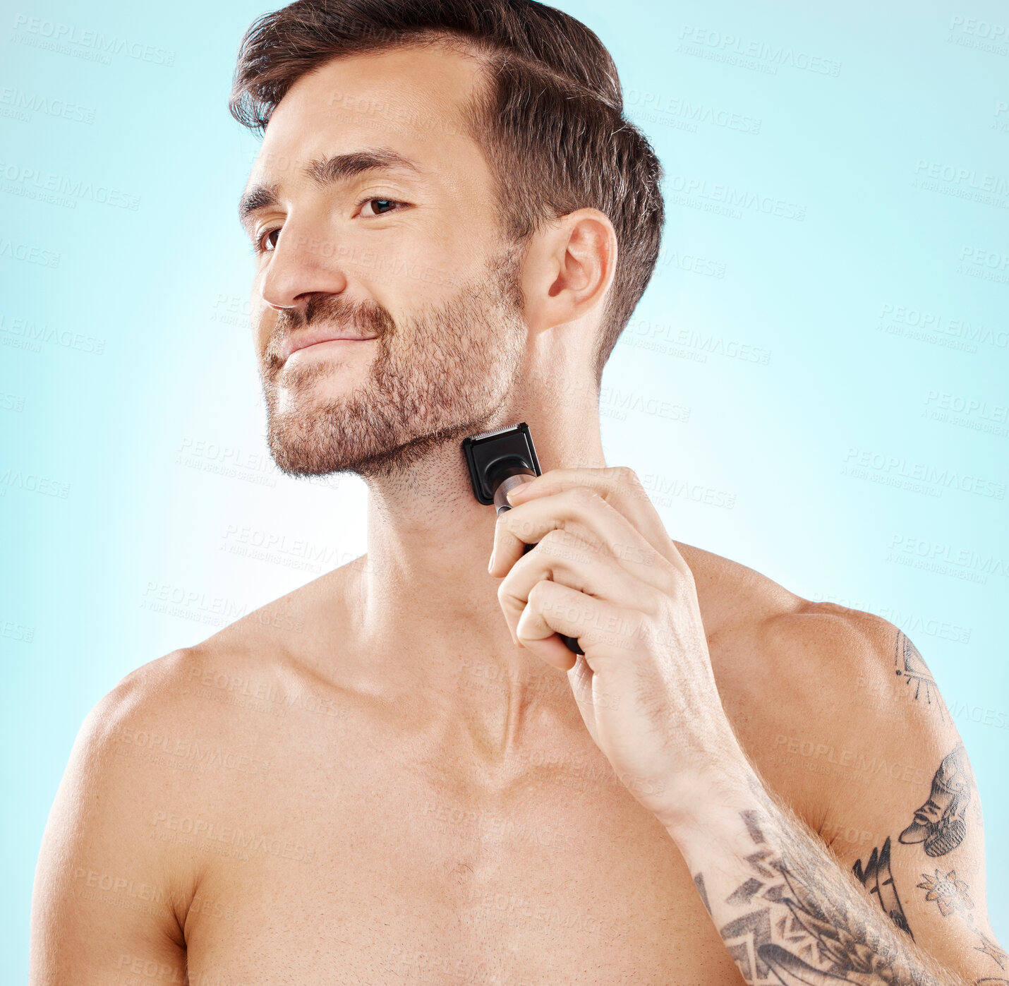 Buy stock photo Man, beard and shaving with trimmer in studio isolated on a blue background for hair removal. Haircare thinking, grooming and male model with electric shaver to shave for hygiene, health or wellness.