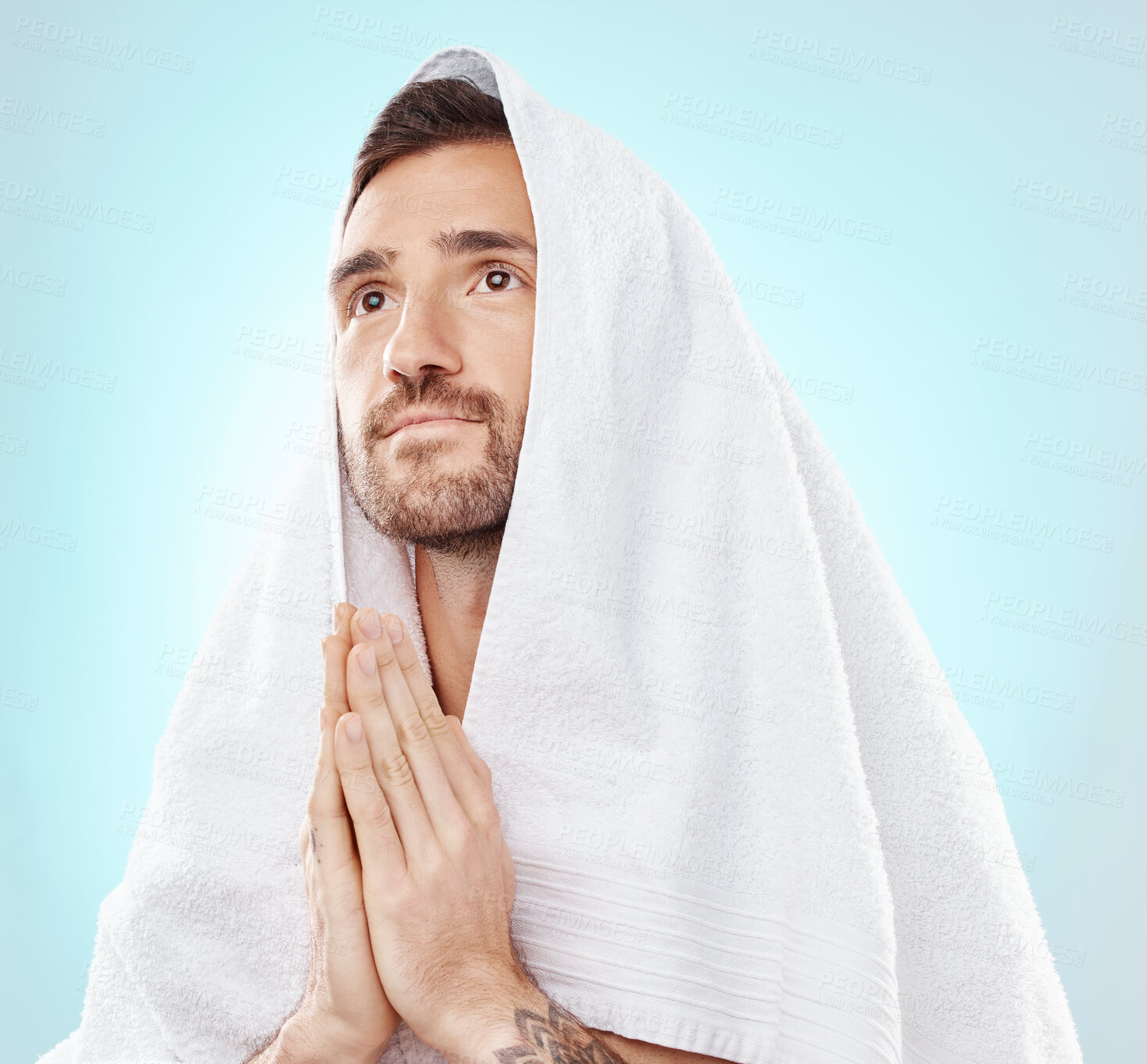 Buy stock photo Prayer, thinking and worship with man and towel for hope, spiritual and Catholic faith. Respect, religion and Holy spirit with guy and hands for believer, humble and Christianity with blue background