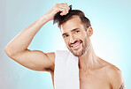 Hair care, man in portrait and beauty with comb and grooming with hygiene on blue background. Cosmetics, clean and fresh with hairstyle, wellness and routine with skin, glow and towel with skincare