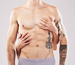 Woman, hands and touch on man chest, abdomen and muscle by studio background for sensual aesthetic. Model, anatomy and sexy with girl, tattoo and six pack for wellness, fitness and health by backdrop