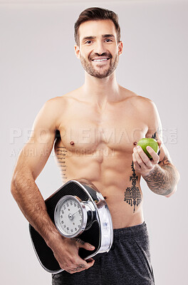 Buy stock photo Health, diet and man, apple and scale, lose weight and smile in portrait, fitness and body, nutrition and fruit. Motivation for healthy lifestyle, weightloss and vegan, wellness on studio background