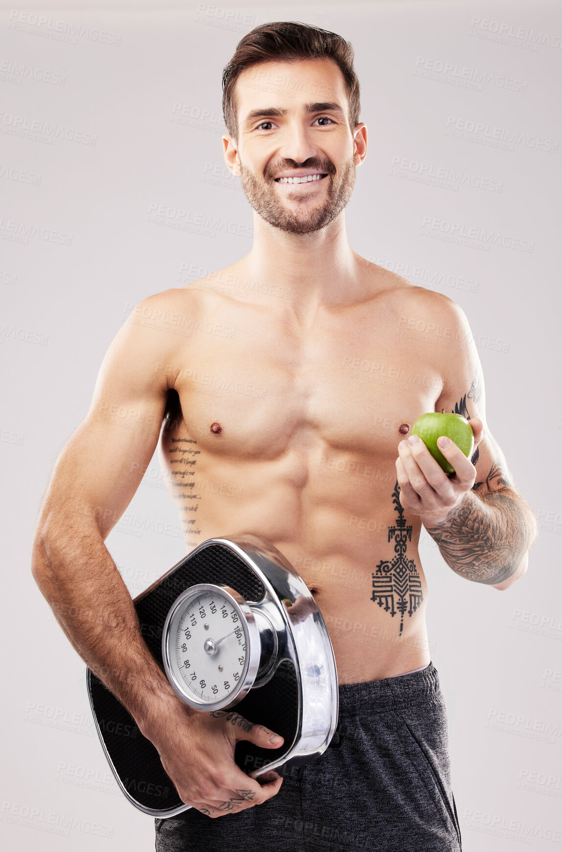 Buy stock photo Health, diet and man, apple and scale, lose weight and smile in portrait, fitness and body, nutrition and fruit. Motivation for healthy lifestyle, weightloss and vegan, wellness on studio background