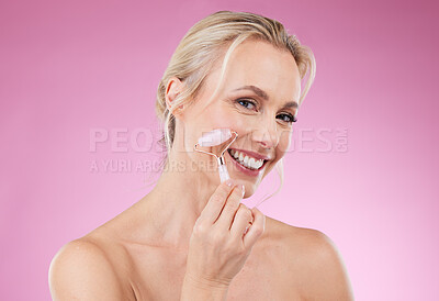 Buy stock photo Beauty, face roller and portrait of woman doing facial massage for dermatology and cosmetics. Happy aesthetic person on pink background for skincare, self care and rose quartz results for health glow