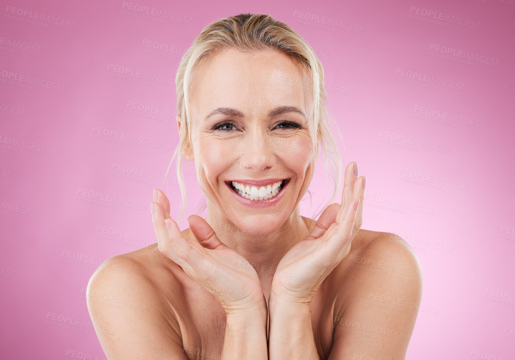 Buy stock photo Beauty, portrait of woman with smile and hands up, glowing skin with natural spa makeup in studio. Mockup, advertising and skincare, luxury cosmetics, face of happy model isolated on pink background.