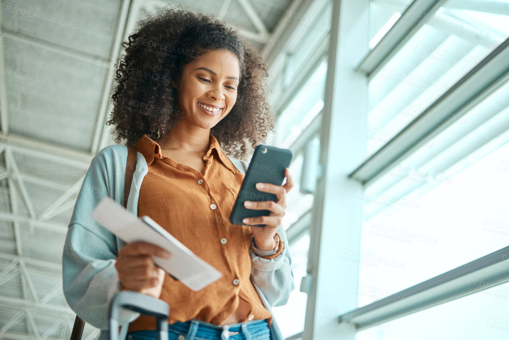 Buy stock photo Black woman at airport, travel with smartphone and plane ticket, communication and check social media with smile. Notification, email or chat with technology, ready for flight and happy for adventure