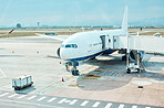 Airplane, airport and runway near terminal and boarding steps for a flight for travel, logistics or commercial transport. Plane, aircraft and airline vehicle outdoors in Cape Town International