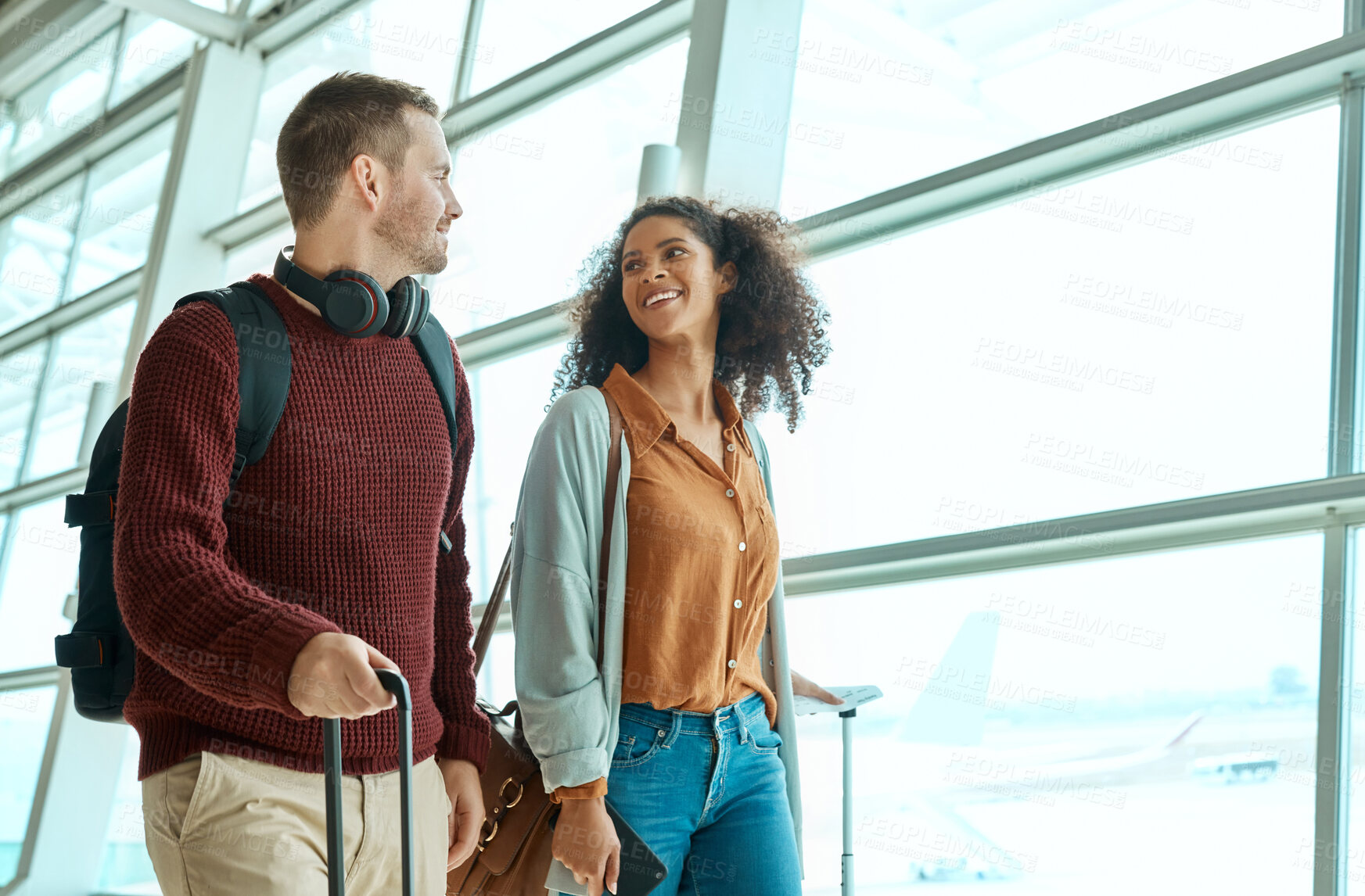 Buy stock photo Travel, love and happy with interracial couple in airport for vacation, tourism and departure. International trip, luggage and holiday with man and black woman walking for flight, journey or airline