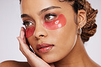 Eyes, beauty and mask on black woman for skincare, cosmetics and dermatology in studio. Face of aesthetic model person on a grey background with facial collagen gel patch for wellness glow on skin
