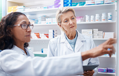 Buy stock photo Pharmacist women, shelf and pointing together for retail, stock or product for medical wellness in store. Pharmacy training, management and teamwork for medicine, tablet and healthcare for solidarity