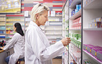 Pharmacy, doctor and medicine retail store with mockup stock on shelf for healthcare industry. Pharmacist woman reading info on pills, box or Pharma product for medical service, health and wellness