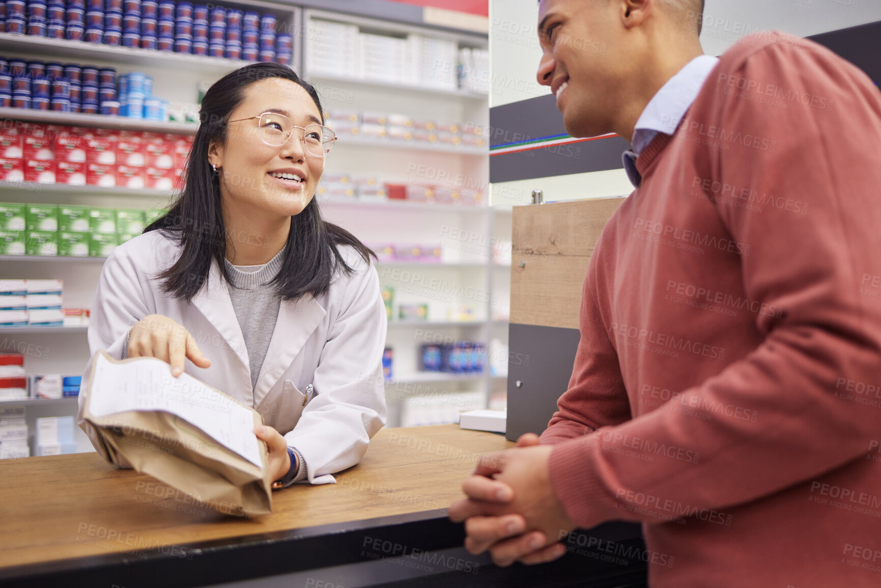 Buy stock photo Pharmacy, paper bag and pharmacist woman for customer service, medical support or retail product help desk. Asian advice, pharmaceutical drugs and healthcare receipt for black man, client or patient