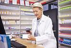 Pharmacy, smile and woman scanning medicine at checkout counter for prescription drugs. Healthcare, pills and certified senior pharmacist with medical product in box and digital scanner in drugstore.