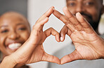 Happy, hands in heart and black couple with smile for relationship, dating and commitment in home. Love, emoji sign and face of black woman and man with hand shape for bonding, romance and trust