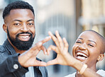 Love, heart hands and smile with portrait of black couple in city for support, trust and romance. Wellness, happy and connection with face of man and woman with gesture for date, emoji and kindness