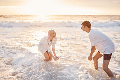 Buy stock photo Couple at beach, splash in water with sea, travel and freedom outdoor, love and care in relationship with youth. Cafe free at sunset, nature and ocean waves with young people on holiday in Hawaii