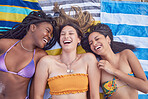 Beach, friends and women laughing for funny talk on vacation, travel or holiday in summer. Above group together on towel for tropical comic time together with diversity, happiness and bikini freedom