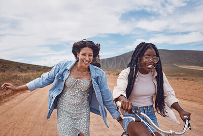 Bike, girl friends and happy road trip fun of women outdoor on a desert path on summer vacation. Cycling, running and freedom of young people together with bicycle transportation feeling free
