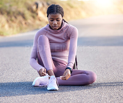 Buy stock photo Fitness, road and black woman tie shoes on street to get ready for running, exercise or workout. Sports athlete, training and female runner tying sneakers to start exercising, cardio or jog outdoors.