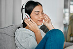 Music, headphones and woman on sofa in home living room streaming radio or podcast. Relax, technology and female with headset for listening or enjoying song, audio or album on couch in house lounge.