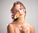 Skincare, flower and portrait of model in studio with beauty, natural and face routine. Floral, health and woman with organic, self care and fresh skin or facial treatment isolated by gray background