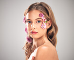 Beauty, flower and portrait of woman in studio for natural cosmetics, skincare wellness and makeup products. Spring, art and girl with petal on face for spa aesthetic, luxury facial and cosmetology