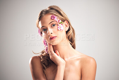 Buy stock photo Beauty, flower and portrait of natural woman in studio for cosmetics, skincare wellness and makeup products. Spring, art and girl with petal on face for spa aesthetic, luxury facial and cosmetology
