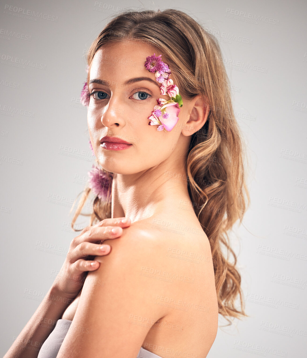 Buy stock photo Flower art, skincare and portrait of woman in studio for natural cosmetics, wellness and makeup. Spring, beauty and girl with face petal for spa aesthetic, facial and cosmetology on gray background