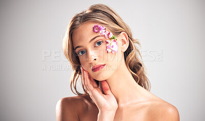 Buy stock photo Beauty, art and portrait of woman with flowers for natural cosmetics, skincare wellness and makeup product. Spring, studio and girl with petal on face for spa aesthetic, luxury facial and cosmetology