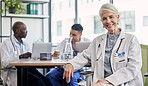 Senior woman, doctor and portrait at hospital desk with smile for healthcare, planning surgery and teamwork. Leader, doctors and experience in health, wellness and happy in clinic with group at table