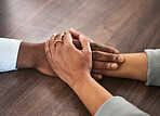 Support, help and couple holding hands for trust, empathy and unity in crisis, cancer or bad news. Solidarity, care and man and woman together on table for praying, comfort and prayer, hope or love.