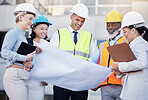 Architect, building and construction team with blueprint in planning strategy, meeting or project layout on site. Group of diverse engineers or contractors discussing floor plan for city architecture