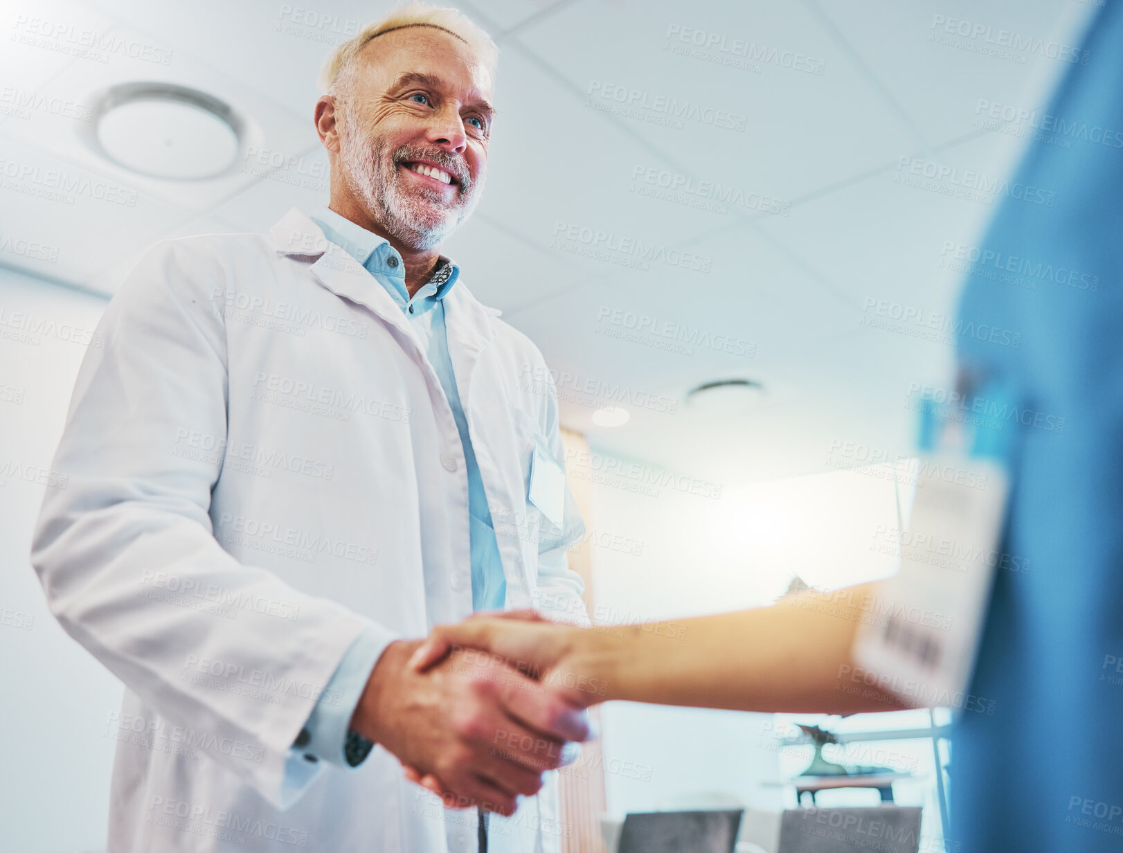 Buy stock photo Healthcare, handshake and doctor in partnership with a nurse for a consultation in the hospital. Happy, smile and senior medical worker shaking hands with colleague for agreement in a medicare clinic