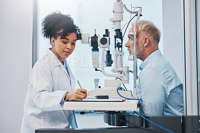 Buy stock photo Vision, eye exam and writing with a doctor woman or optometrist testing the eyes of a man patient in a clinic. Hospital, medical or consulting with a female eyesight specialist and senior male